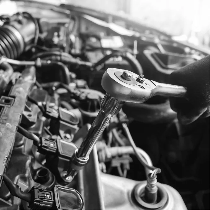 Werkzeug im Einsatz bei der Reparatur eines Motors, symbolisiert präzise Arbeit und Expertise in der KFZ-Technik